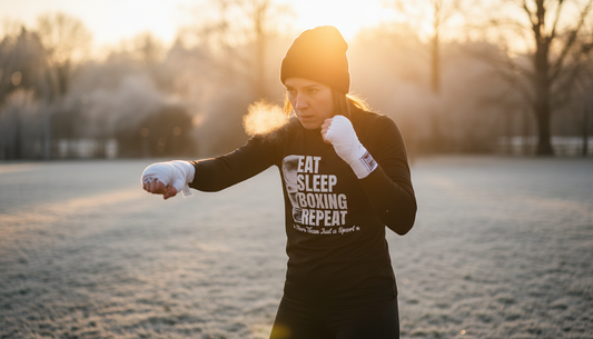 Boxerin beim Schattenboxen im winterlichen Park bei Sonnenuntergang - Outdoor-Training in goldener Stunde