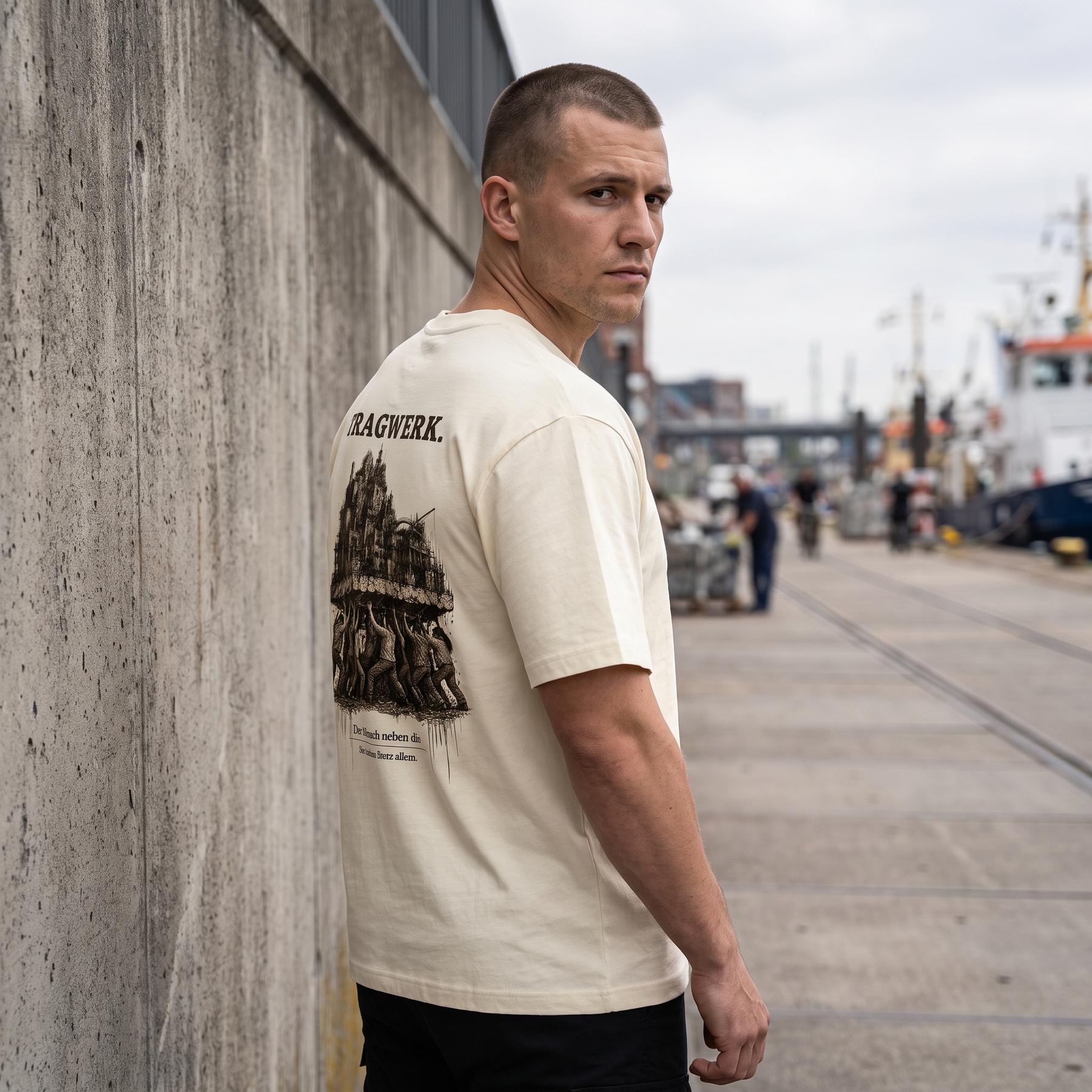 Mann trägt TRAGWERK. Heavy T-Shirt am Hafen