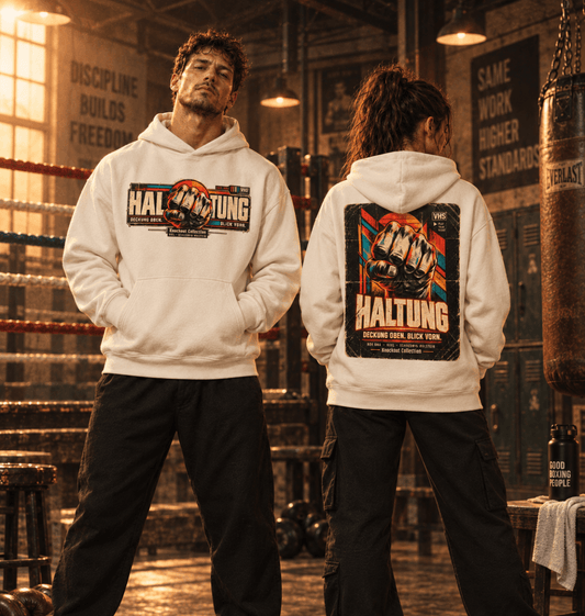 Mann und Frau tragen Natural Raw HALTUNG Ultra Heavy Hoodies mit Front- und Rückenprint in einer Boxhalle